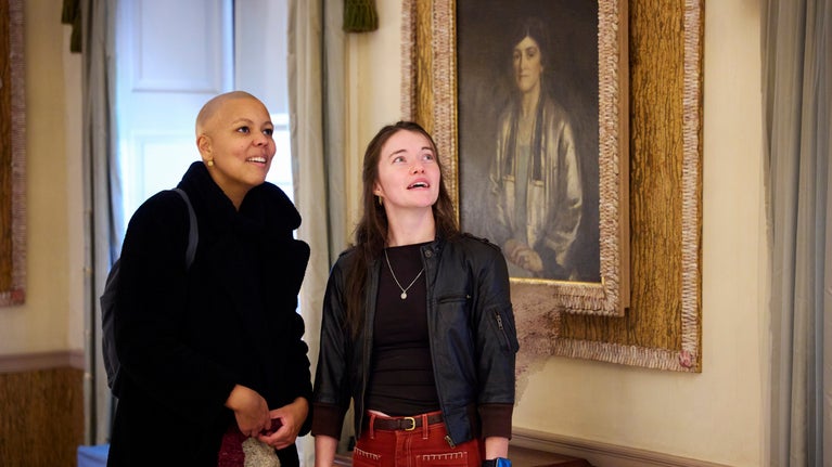 Two people standing in warm coats admiring the house at at Basildon Park in Berkshire